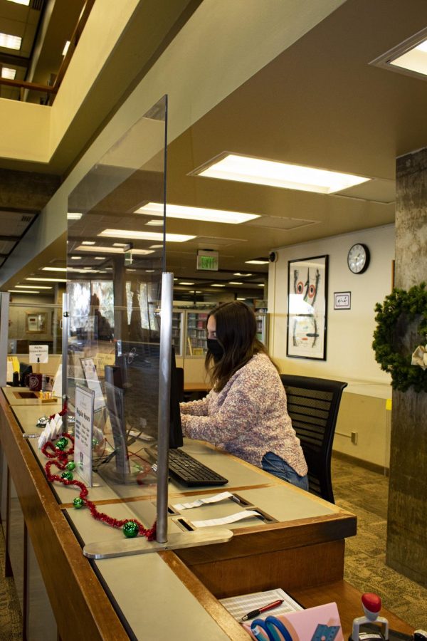 Student working on campus at the library front desk