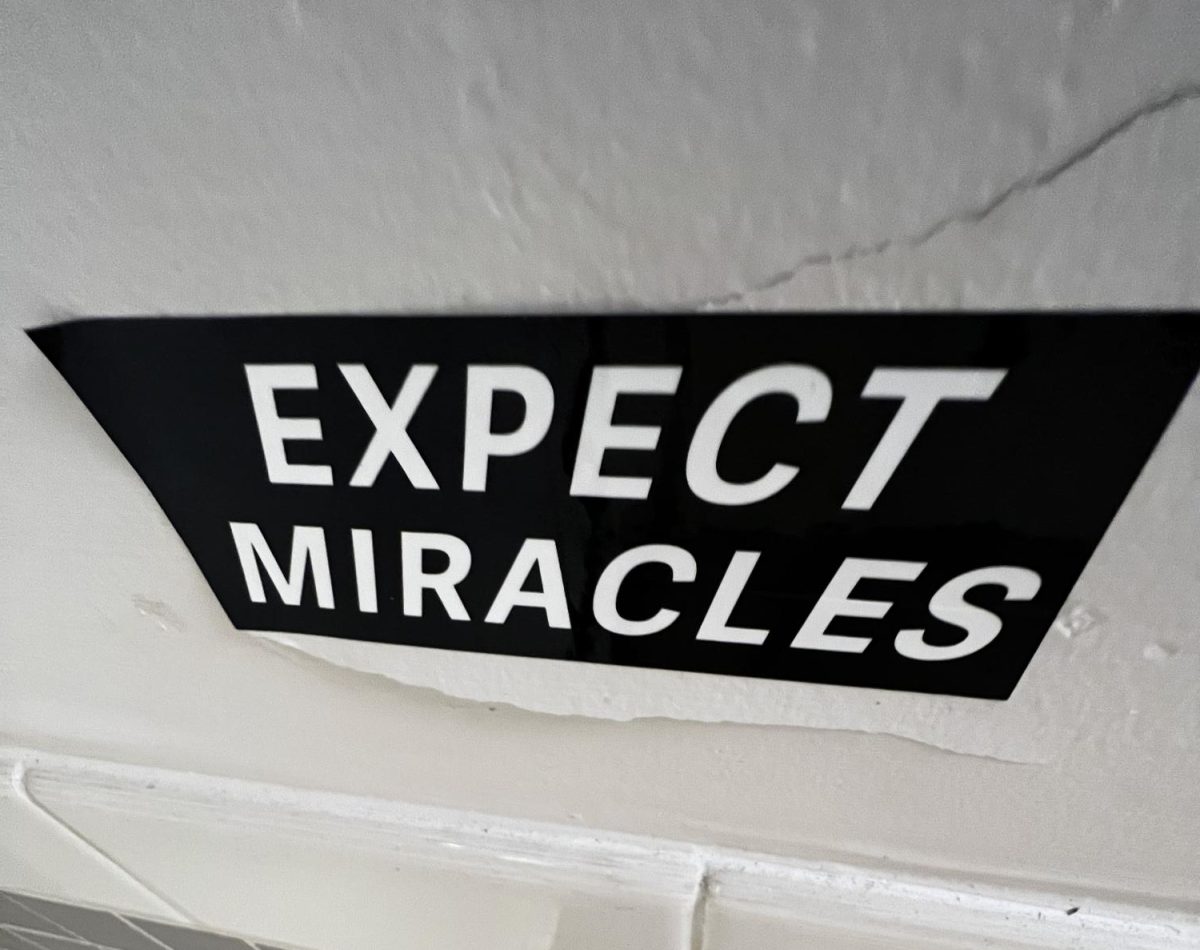 Expect Miracles sticker on bathroom wall