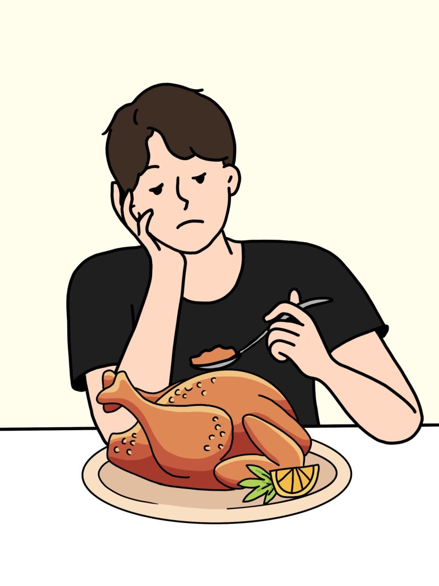 A student dejectedly picks at a plate full of turkey.