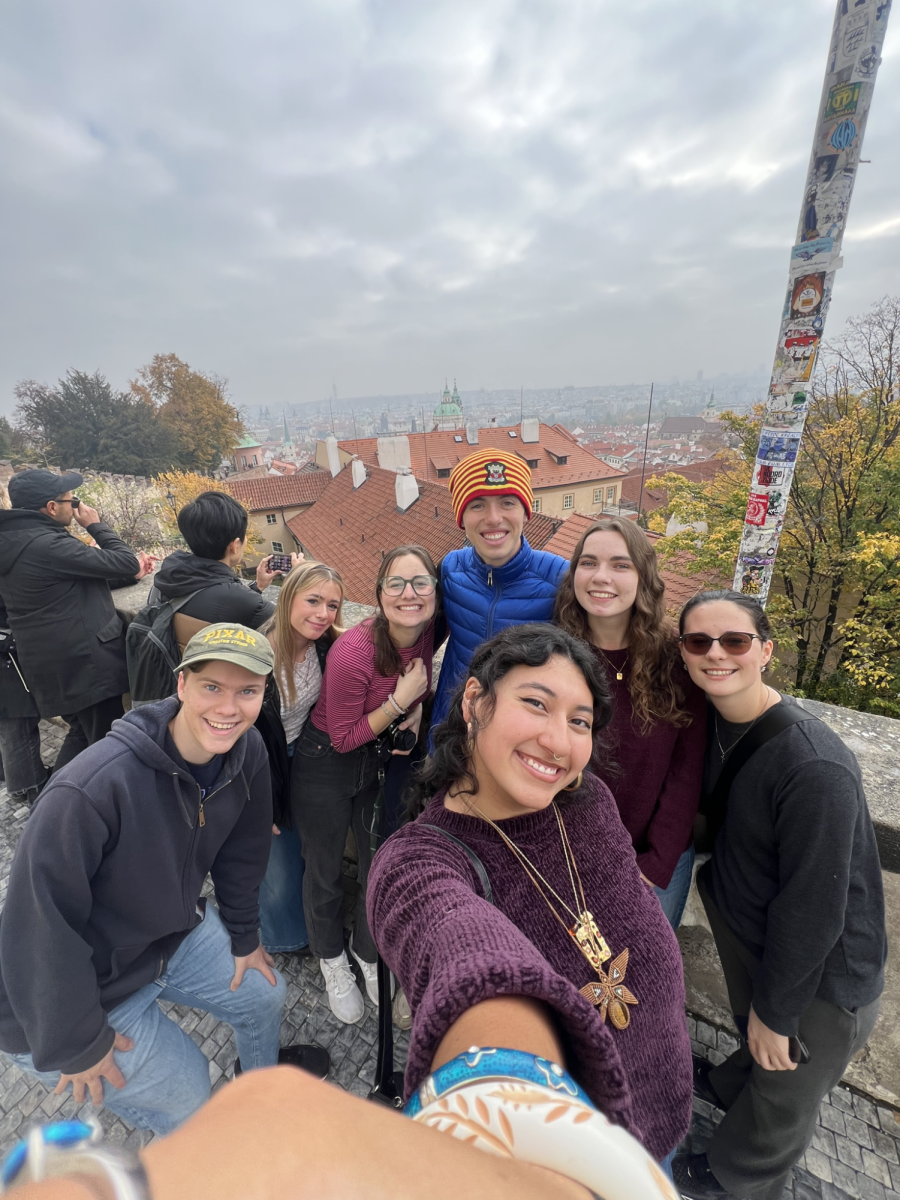 Westmont students pose for a photo on the rooftop of a building overlooking a city.