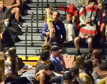 Pastor Scott walks through the gym during chapel carrying a yoke past a student who was accidentally knocked out.