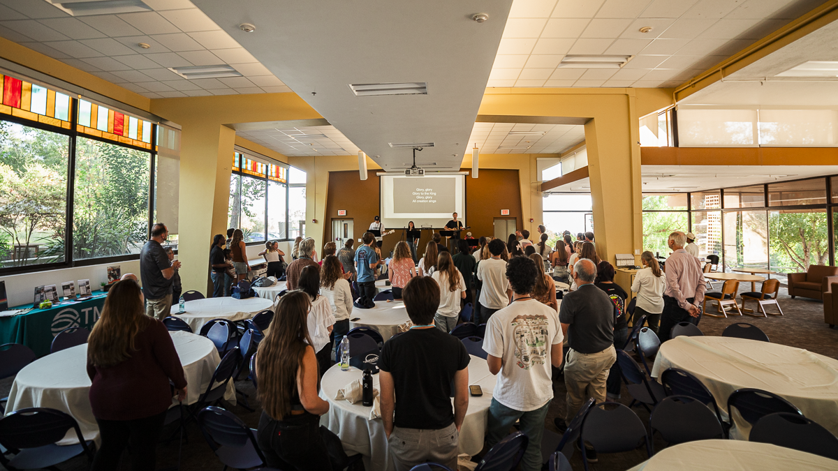 Students stand in the Page Multipurpose Room for worship during the Santa Barbara Sending Conference.