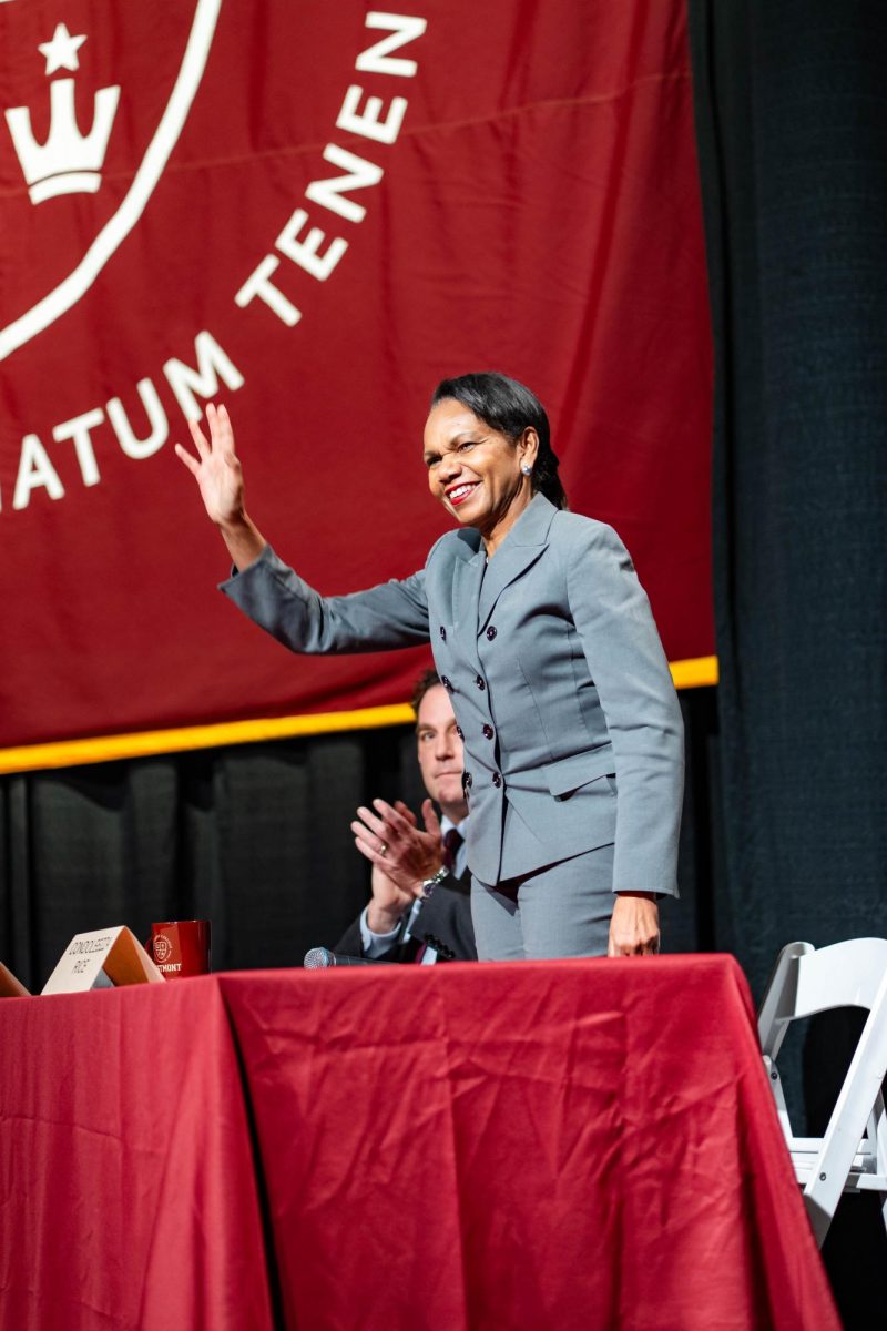 Condoleezza Rice waves from the chapel stage before she begins her panel interview.